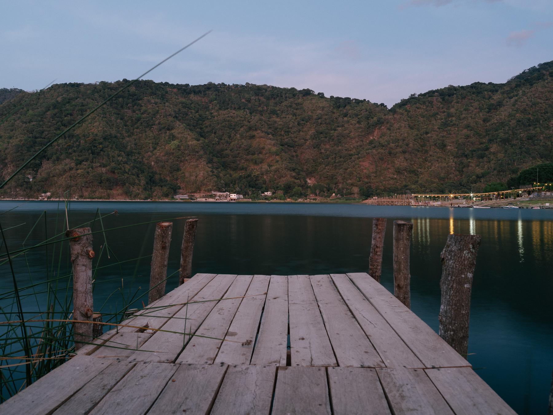 Il pontile in legno di Venecia al tramonto, davanti alle montagne del Lago de Atitlán